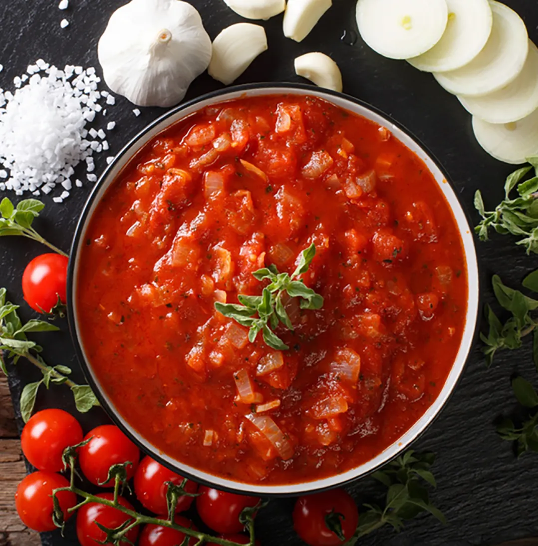 salsa pomarola en un plato con fondo en una mesa de madera